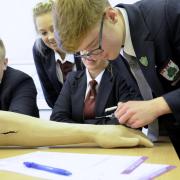 Ridgewood High School pupils Will Chilton, Taylor Handley and Dawson Jones take blood out of an injection arm