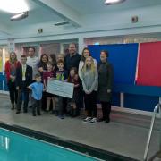 Alison and Dave Banner with Daniel's brother Jake and sister Katie, plus family and friends who took part in the sponsored swim, and event organiser Michael Harley from Learning4life, pictured handing the money over to Birmingham Women and Children