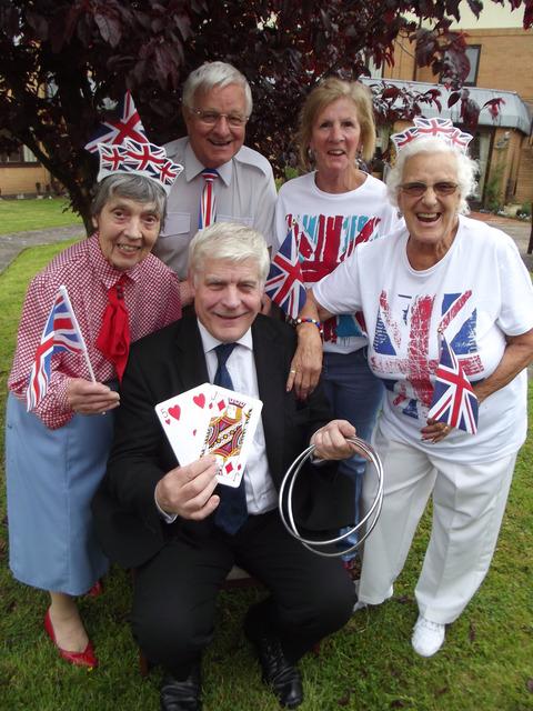 Committee members Sheila Smith, Vic Beddoes, Val Lee and Rosina Laxton from Elizabeth House in Lye celebrate with magician John Milner.