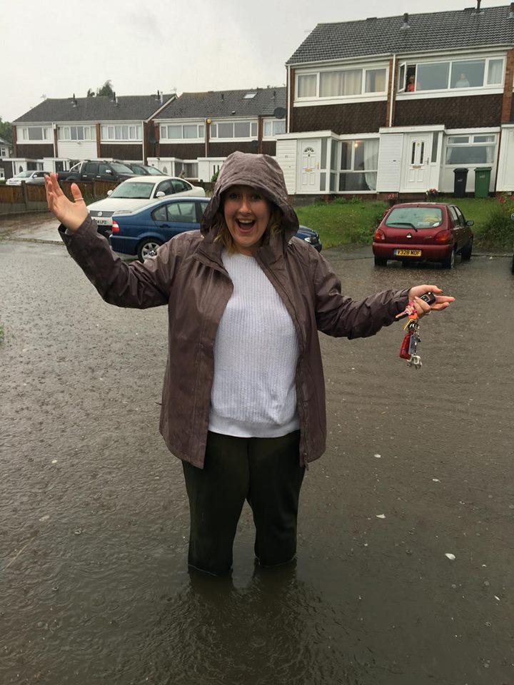 Claire Shaw braves the flood water to get to her car on the Caledonia Estate, Quarry Bank.