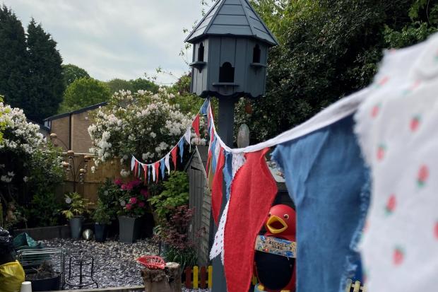 Residents in Shepherds Brook Road hang out the bunting for VE Day