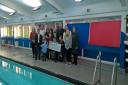 Alison and Dave Banner with Daniel's brother Jake and sister Katie, plus family and friends who took part in the sponsored swim, and event organiser Michael Harley from Learning4life, pictured handing the money over to Birmingham Women and Children