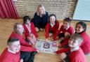 Suzanne Webb MP with Amblecote Primary School students and their winning designs from the MP's A Card for the Queen Platinum Jubilee competition