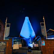 The Red House Glass Cone bathed in blue light in support of the NHS
