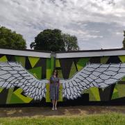 Cllr Cat Eccles poses for a pic in front of the new artwork created by Cal in Swan Pool Park.