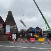 A crane lifts scaffolding onto the site of the Red House Glass Cone at Wordsley