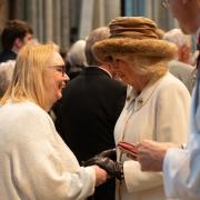 Queen Camilla handing Maundy Money to Kath Davis - a worshipper at St Andrew's Church in Wollescote
