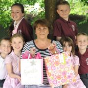 Retiring headteacher Gill Harper, centre, with, front l-r, pupils Joshua Southall, aged five, Daisy Allen, aged seven, Lucy Scott, aged five, Adam Morgan, aged seven; and – back - Amy Gorman, aged 10, and Oliver Powell, aged 10. Pic - Phil Loach