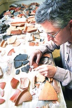 Dr Denis Williams, county archaeologist, examines some of the thousands  of Roman pottery shards fuond on the Castle Street site.